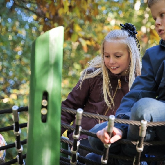 Børn leger på naturlegepladsen ved De fem Halder. Legepladsen er omgivet af skov og historiske omgivelser ved Hald Sø nær Viborg. 